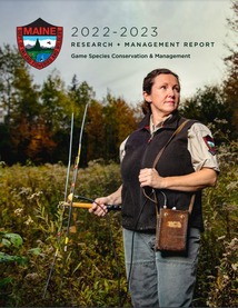 wildlife biologist in field in the fall holding wildlife tracking equipment 