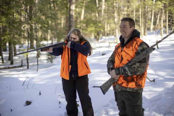 Male and female hunters in winter wearing blaze orange