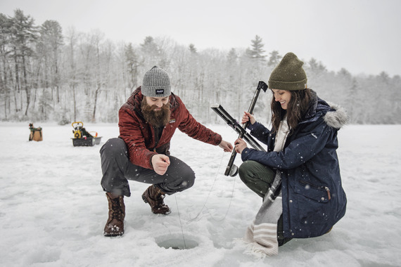 two people ice fishing with snowy setting