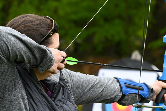 A person shooting an arrow at a target at a range.