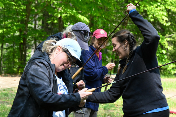 An instructor teaching several students how to cast a fly rod