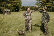 Two hunters setting turkey decoys