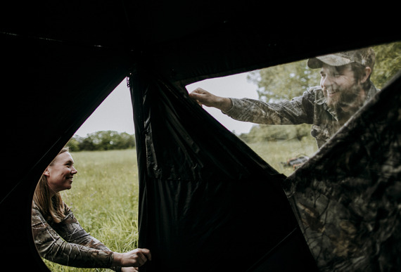 two hunters setting up a blind on the edge of a field