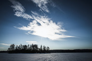 frozen lake with sun shining and blue skies