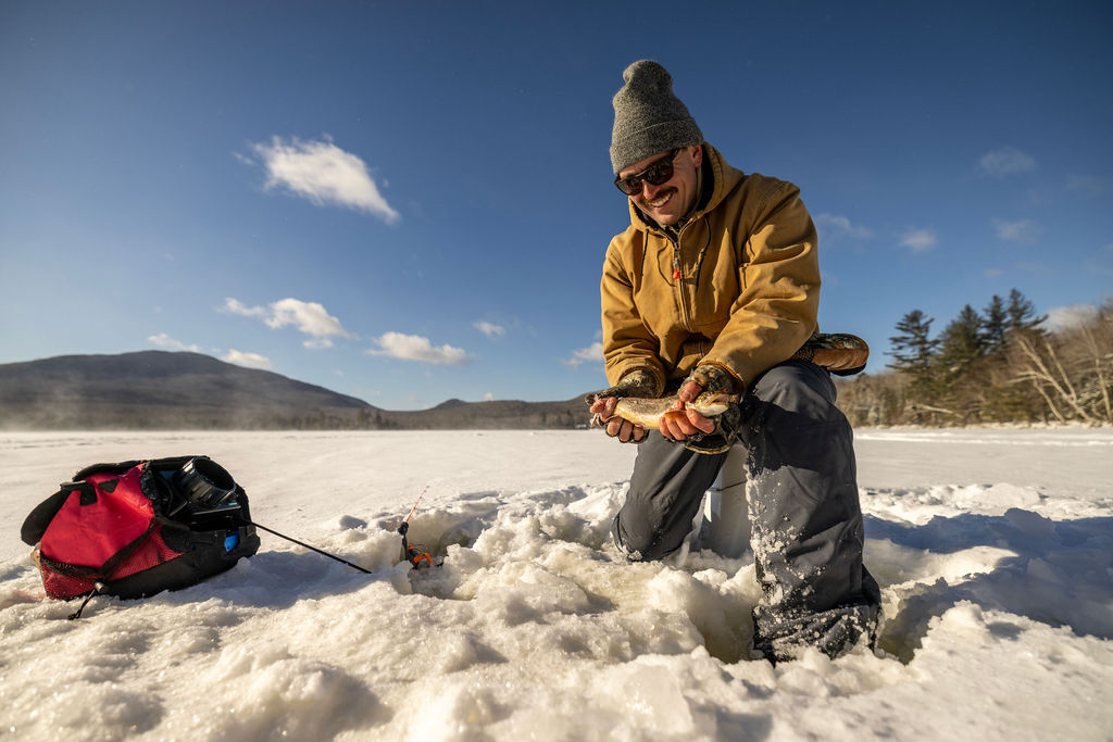 angler holding splake he caught jigging
