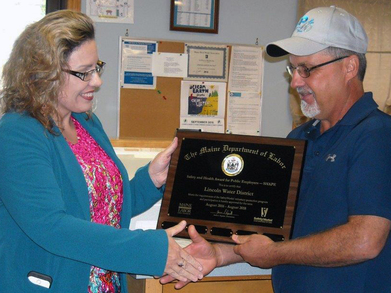 Jeff Day, Superintendent at Lincoln Water District, receives the SHAPE award from Pamela Megathlin, Director, Bureau of Labor Standards at Maine Depar