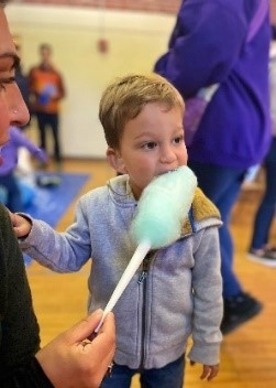 This is a graphic showing Child eating cotton candy at the Deaf Culture Festival