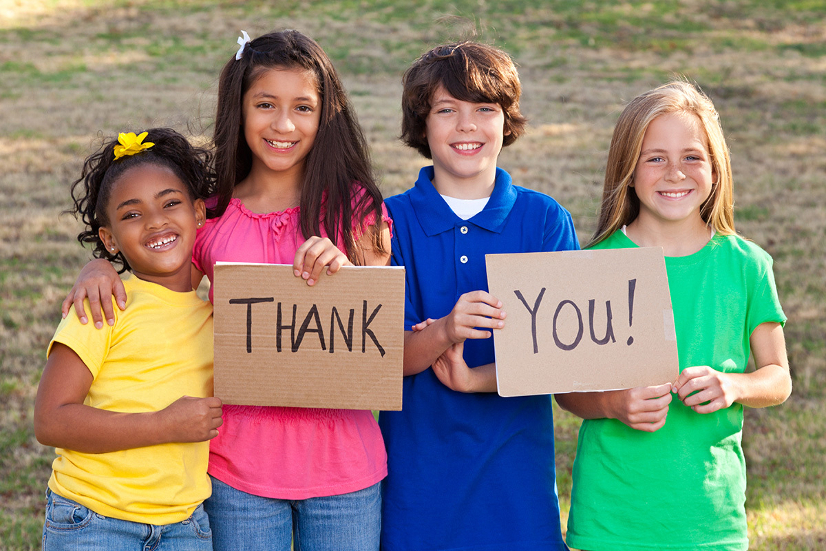 Diverse group of children holding thank you sign