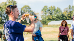 Farmer lifting ear of corn to show field day participants
