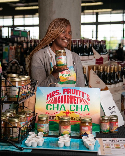 Photograph of Linda Kay Pruitt displaying her gourmet cha cha products in a grocery store