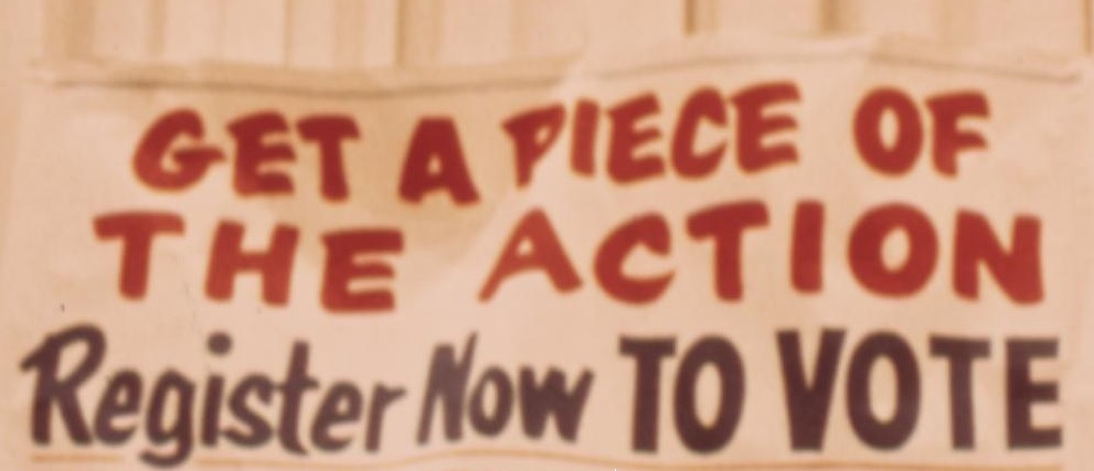 Picture of a historical banner with text: Get a piece of the action. Register now to vote