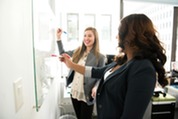 Women in an office working on a whiteboard