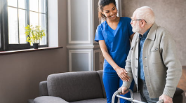 home health aide helping a patient walk