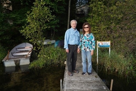 The Wandells At Their Dock Next To Their Shoreland Stewards Gold Level Sign Photo Credit Mark Bugnaski Photography