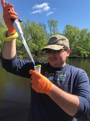 Geoff Rhodes collecting PFAS sample from a stream in Michigan.