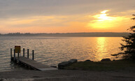 Boat dock on lake at sunset.