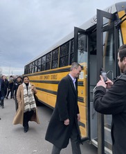 Phil Roos, Regina Strong, and Debra Shore board an electric school bus in Pontiac.