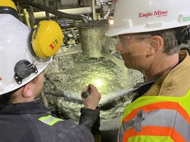 EGLE Director Phil Roos, right, listens as an Eagle Mine representative explains the process of extracting nickel from ore at Humboldt Mill.