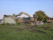 An excavator demolishes a building at the site of the Hillman Sports Center redevelopment in Hillman.