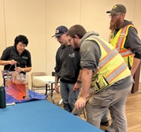 EGLE staffer Pam Howd demonstrates how radon can migrate through the soil and groundwater to get into structures.