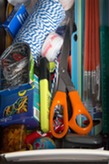 A picture of a drawer full of scissors, twine, rubberbands, markers, tape, paintbrushes, etc.
