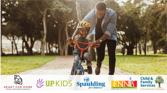 Foster dad helping his child ride a bike.