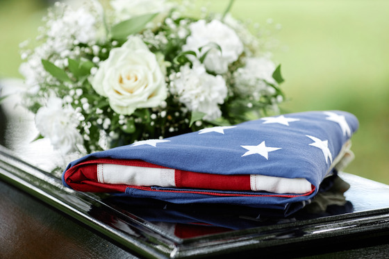 coffin with flowers and American flag