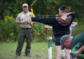 Girl learning to use archery equipment