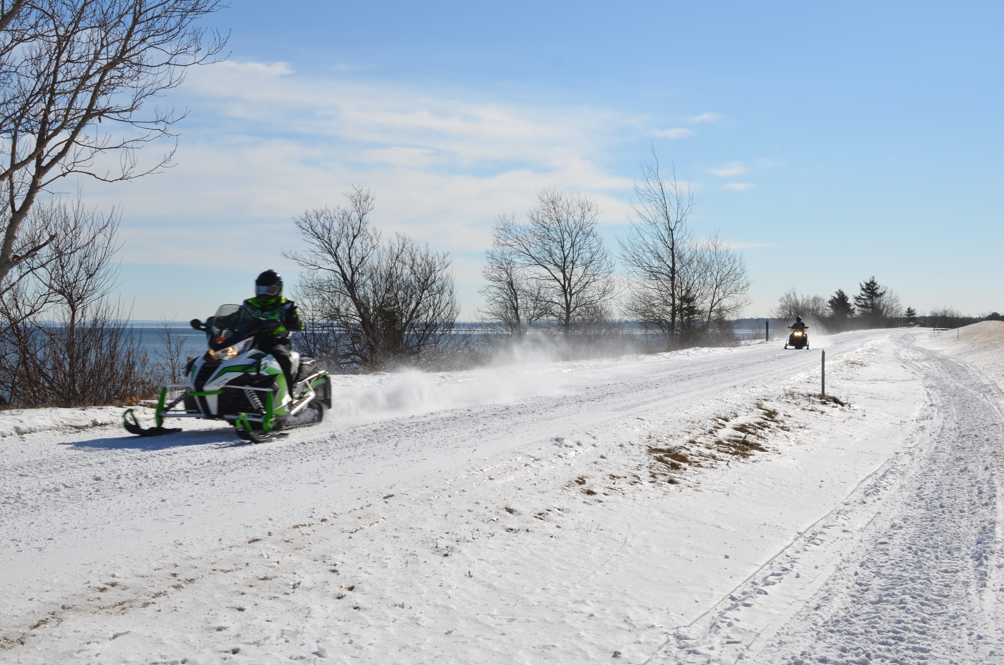Two snowmobile riders head toward Marquette on a trail along Lake Superior March 4.