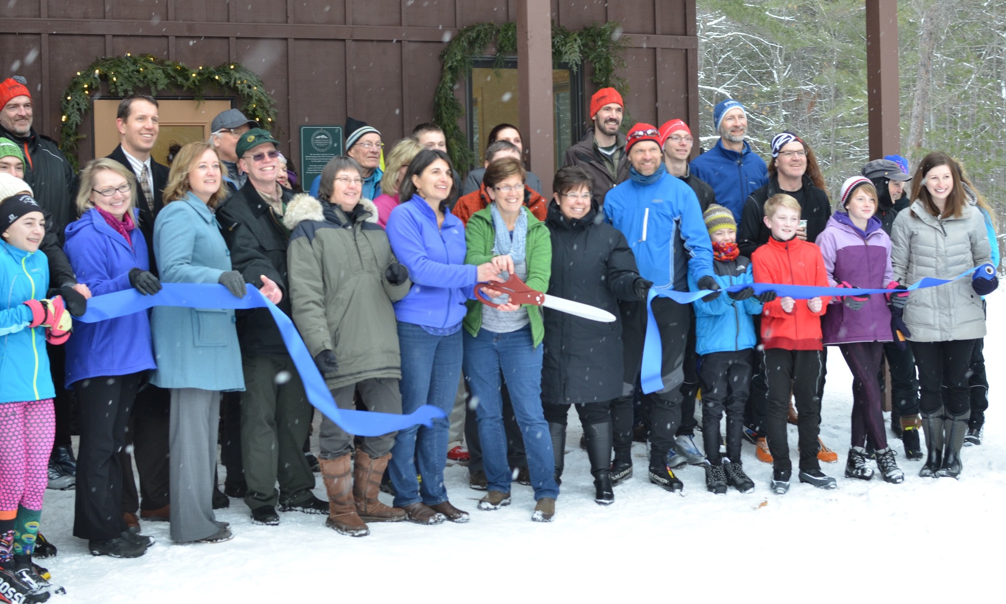 A large group of skiers, project partners and others gathered outside the warming hut for a ribbon-cutting ceremony.