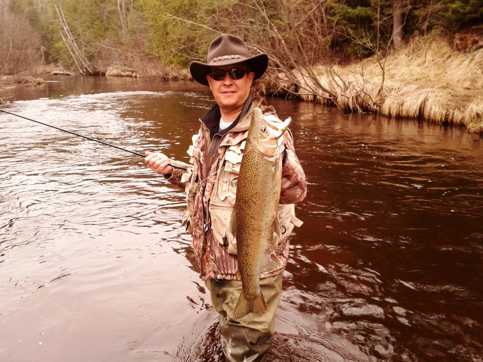 Charles Dennison and a steelhead catch on his Upper Peninsula fish camp river.