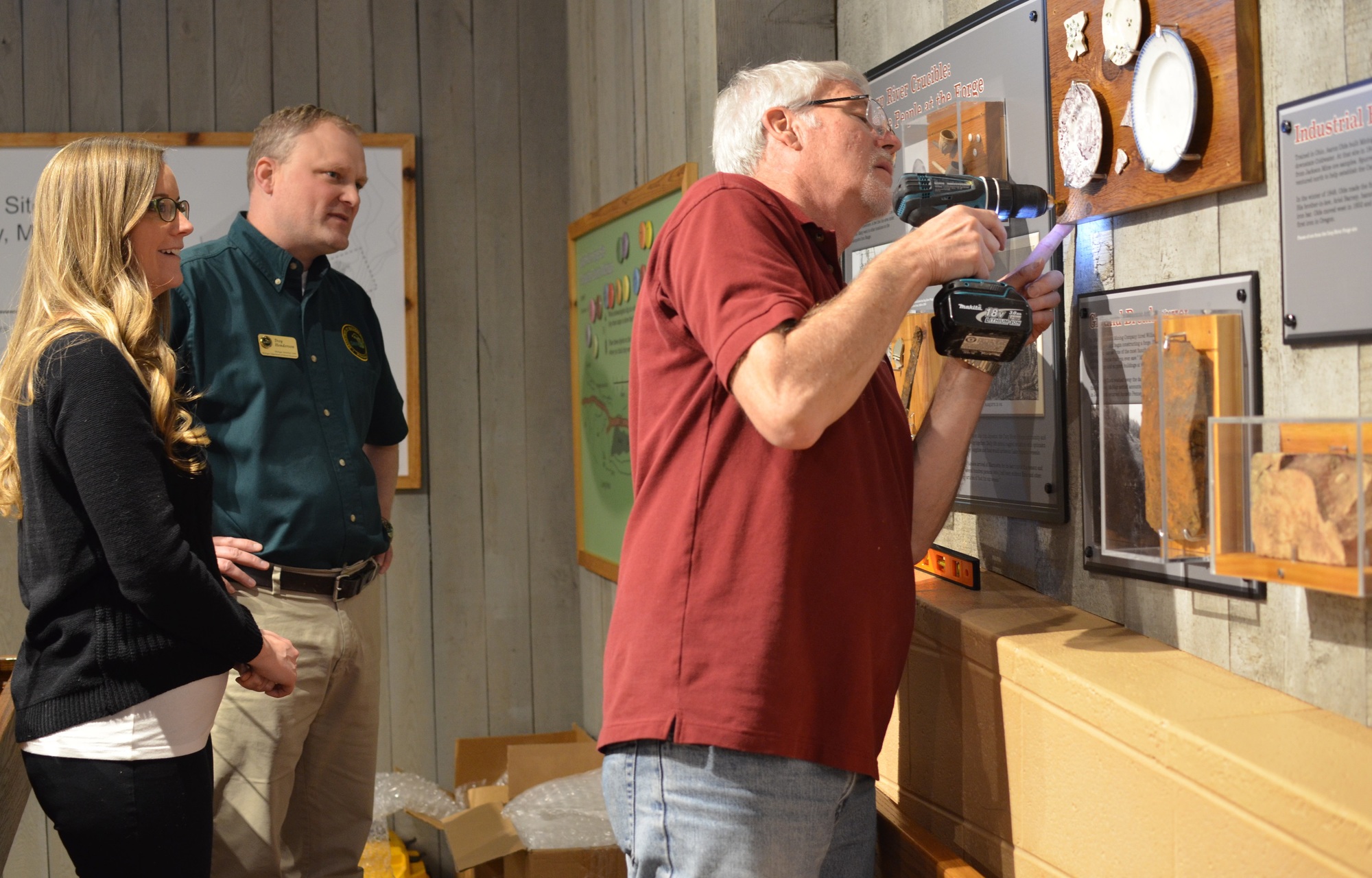 Steven Ostrander, a historian with the Michigan Historical Center, works on installing a display that is part of the Carp River Forge exhibit.