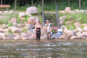 Fishing clinic instructor and student fishing in river
