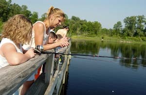 Family fishing from dock at Wolf Lake State Fish Hatchery
