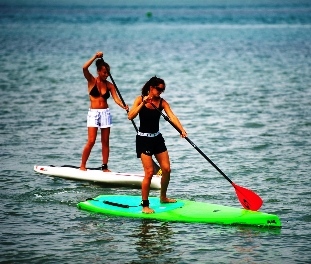 Two girls paddleboaring.