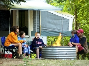 Family camping by a firepit.