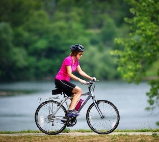 Biker by water on trail