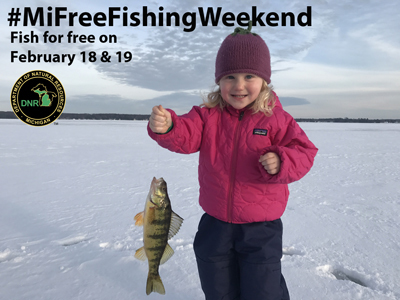 Girl holding up a fish while out ice fishing