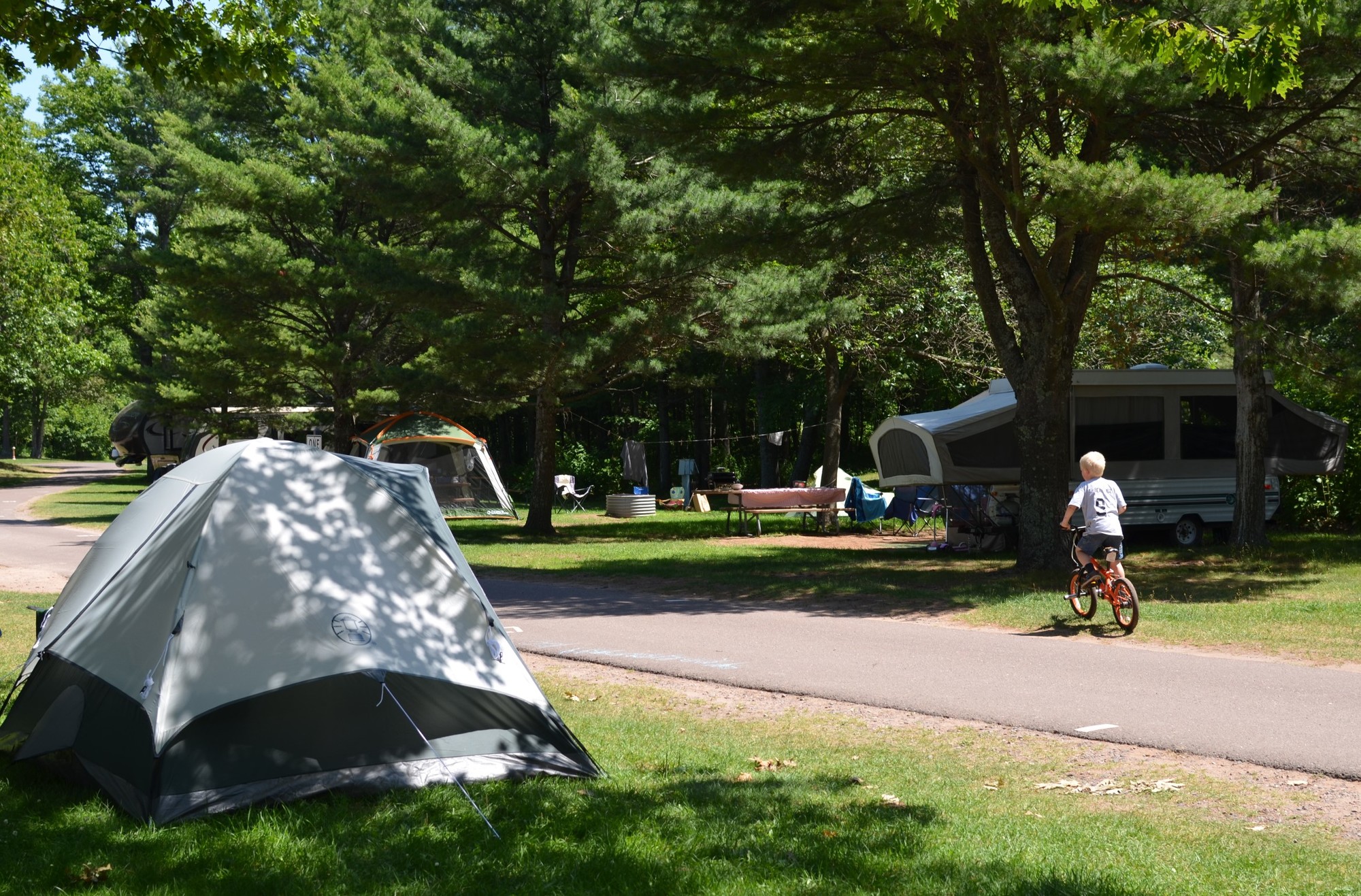 A boy enjoys an afternoon bike ride through the campground at F.J. McLain State Park in Houghton County.