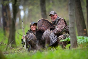 male and female hunters with harvested wild turkey