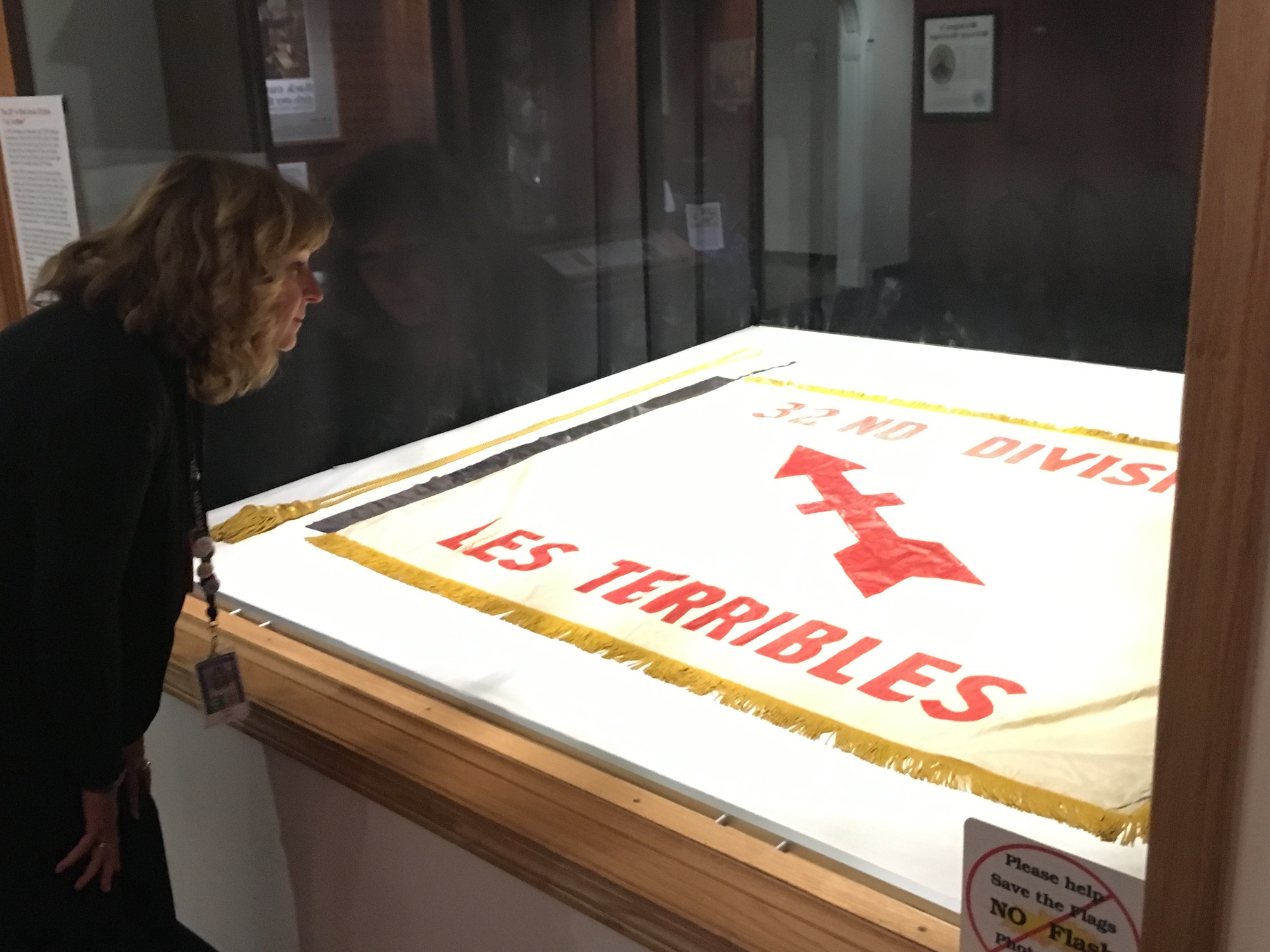 A museum visitor studies a World War I flag of the 32nd Division, now on display on the first floor of the Michigan History Center in Lansing.