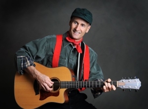 Performer Bill Jamerson, in lumberjack costume, holding a guitar