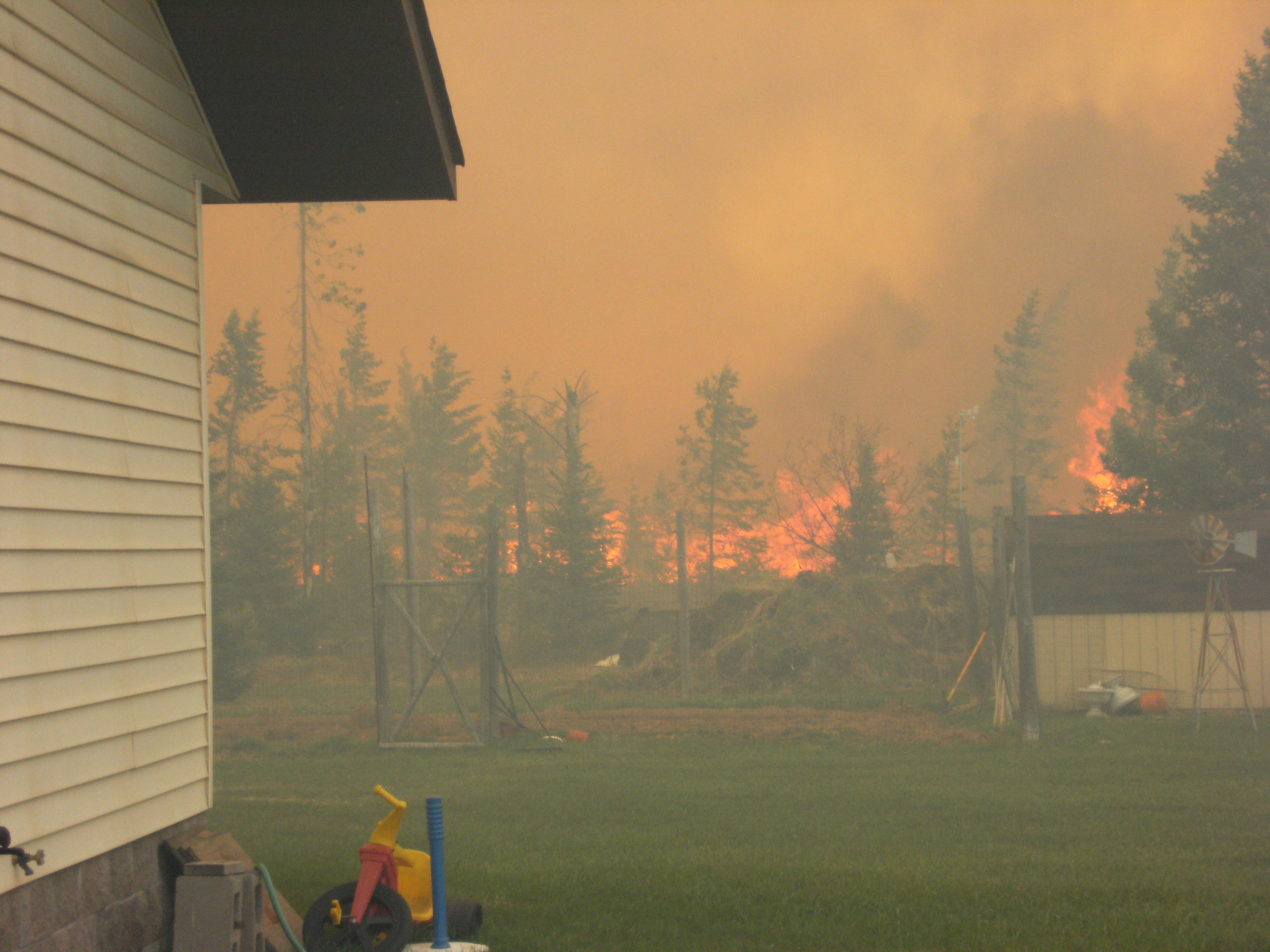 The Black River Falls Fire rages just beyond the backyard of a home in Ely Township in Marquette County.