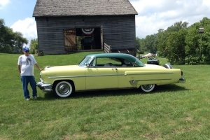 man stands next to 1954 lemon yellow Lincoln Capri with lime green trim, 2016 Best of Show winner