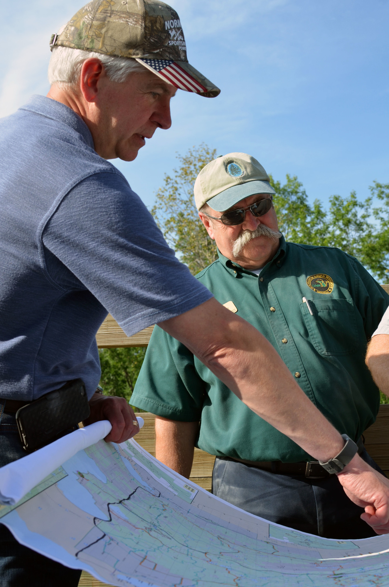 Gov. Rick Snyder, talks with trails group representatives while looking at a map of the central Upper Peninsula Wednesday.