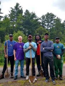 group of teen volunteers holding shovels