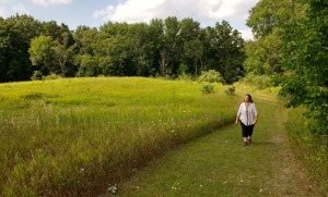 lady walks through meadow near start of Walker Tavern trail