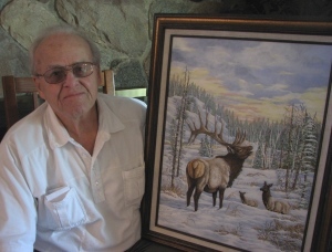 Gary Cole of Dearborn with his original acrylic painting of elk in a wintry landscape.