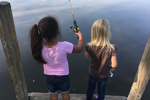 two girls fishing off a dock