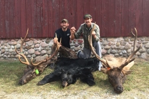 Pure Michigan Hunt winner Jerry Peak with son Jim and harvested elk and bear